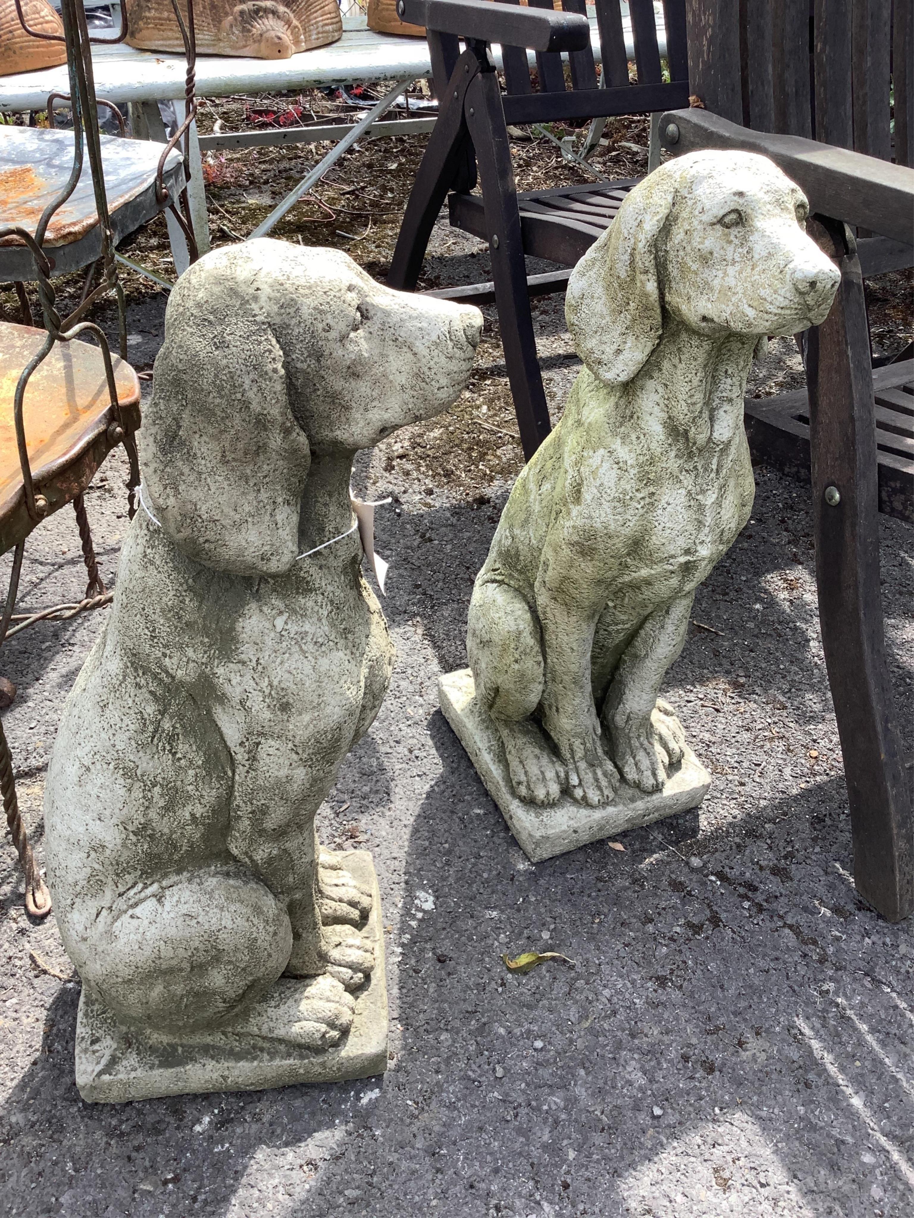 A pair of reconstituted stone seated hound garden ornaments, height 68cm. Condition - good
